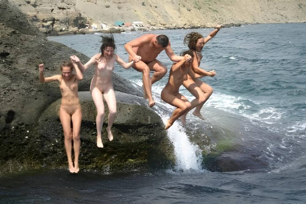 Mens and girls nudists on a beach - nudism and naturism